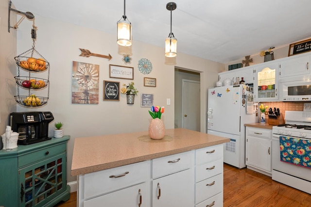 kitchen with decorative backsplash, wood finished floors, white appliances, light countertops, and white cabinetry