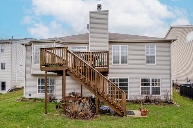 back of property featuring a wooden deck, a chimney, stairs, and a lawn
