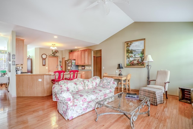 living room featuring light wood-type flooring, ceiling fan, and vaulted ceiling