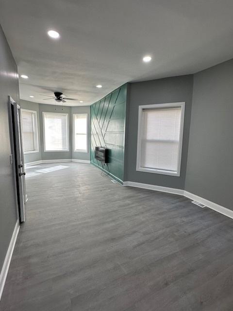 4024 W Polk St, Chicago, IL 60624 - unfurnished living room featuring dark wood-style flooring, baseboards, and recessed lighting