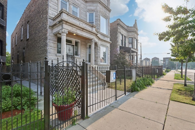3220 W Polk St, Chicago, IL 60624 - view of front of house with a fenced front yard, a gate, stone siding, and a residential view