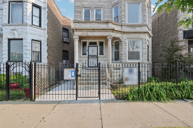 3220 W Polk St, Chicago, IL 60624 - view of front of house featuring stone siding, a fenced front yard, and a gate