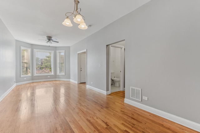 3220 W Polk St, Chicago, IL 60624 - unfurnished room featuring a ceiling fan, a chandelier, baseboards, and light wood-type flooring
