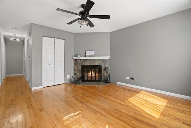 24860 W Forest Dr, Lake Villa, IL 60046 - unfurnished living room with wood finished floors, a ceiling fan, a tile fireplace, and baseboards