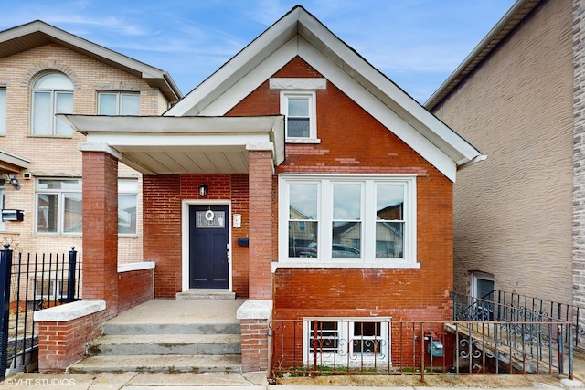 view of front of house featuring fence and brick siding