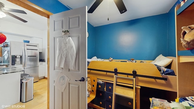 bedroom with stainless steel fridge with ice dispenser, light wood-style floors, and a ceiling fan