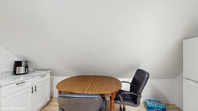 home office featuring baseboards and vaulted ceiling