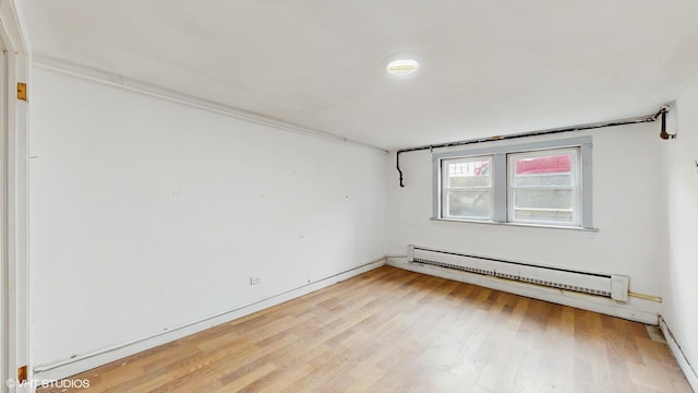 empty room featuring light wood-style flooring and baseboard heating