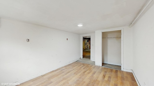 unfurnished bedroom featuring light wood-style flooring and a closet