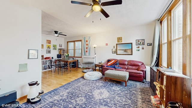 living room featuring wood finished floors, a textured ceiling, and ceiling fan