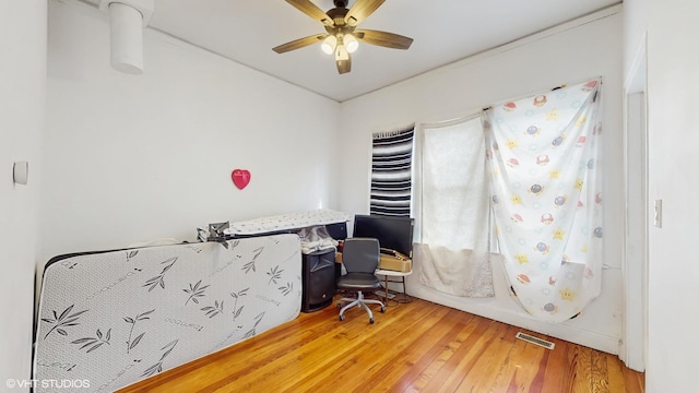 office space featuring visible vents, wood finished floors, and ceiling fan