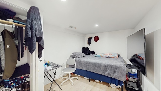 bedroom featuring baseboards, wood finished floors, and recessed lighting