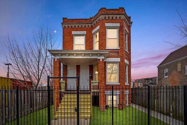 view of front of home featuring a fenced front yard, a gate, covered porch, brick siding, and a yard