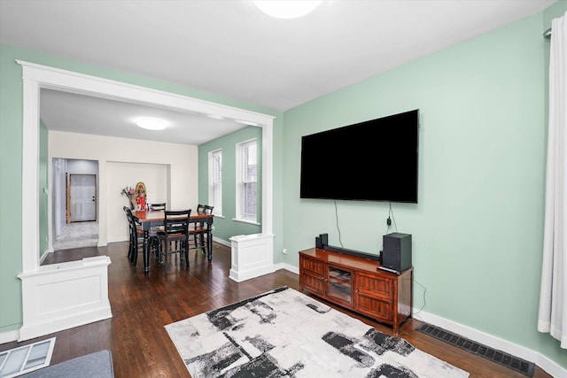 living room featuring baseboards, dark wood-style floors, and visible vents
