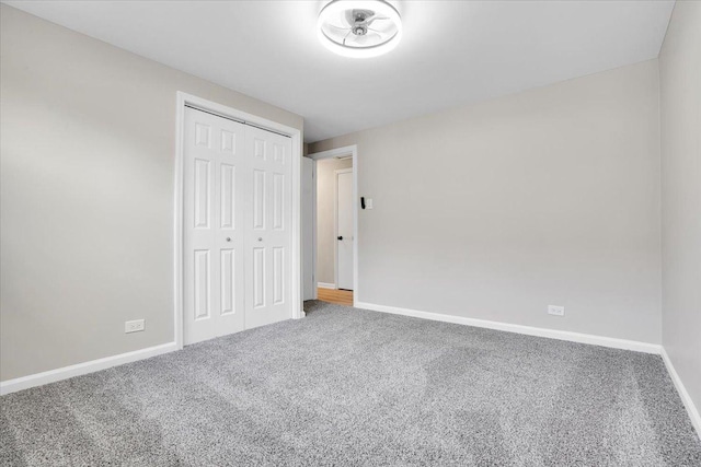 unfurnished bedroom with baseboards, a closet, and carpet