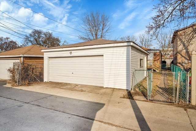 detached garage with a gate and fence