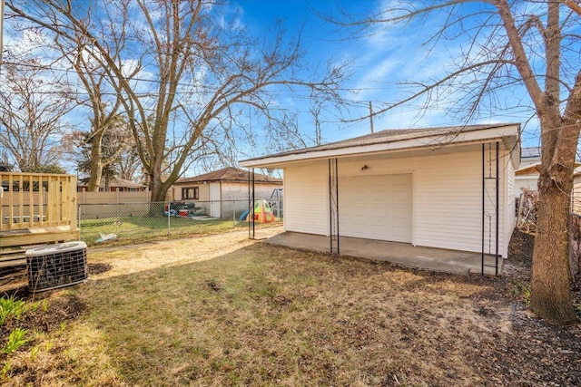 view of yard featuring central air condition unit, a garage, fence, and an outdoor structure