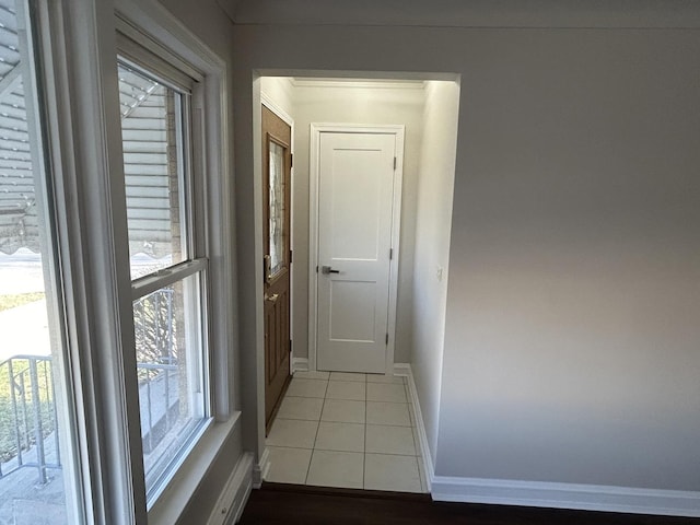 corridor with tile patterned floors and baseboards