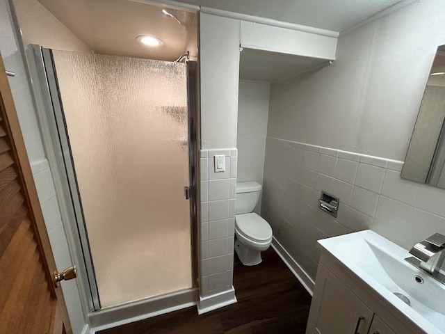 bathroom featuring a shower stall, toilet, vanity, and tile walls