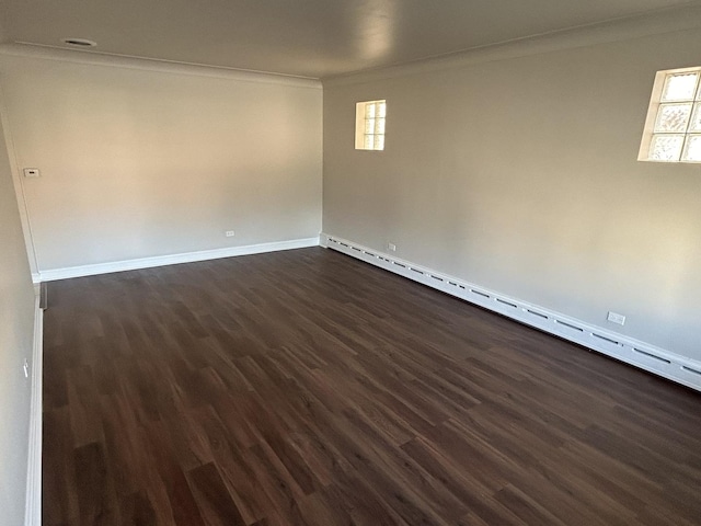 unfurnished room with baseboards, crown molding, a baseboard radiator, and dark wood-type flooring