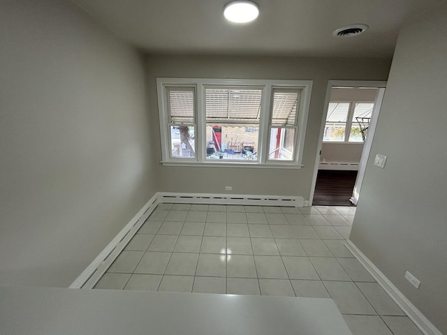 spare room featuring light tile patterned floors, baseboards, visible vents, a baseboard radiator, and baseboard heating