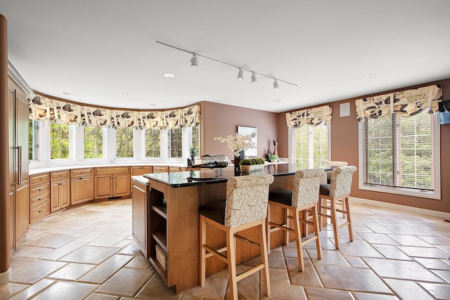 621 Chatfield Rd, New Lenox, IL 60451 - kitchen featuring track lighting, a breakfast bar, stone tile floors, and a center island
