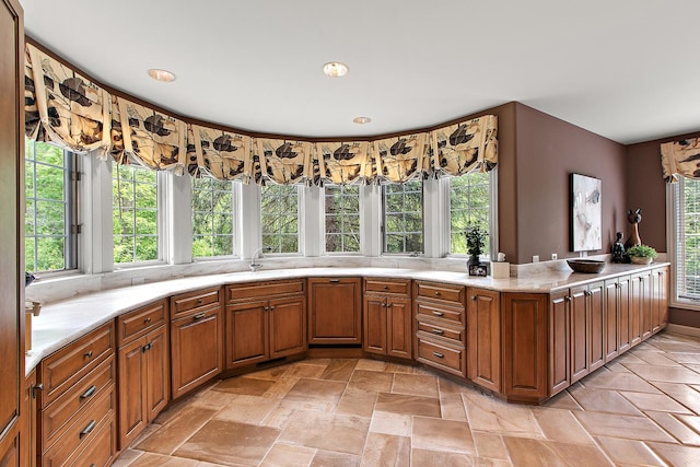 621 Chatfield Rd, New Lenox, IL 60451 - kitchen with brown cabinetry, light stone finish floors, light stone counters, recessed lighting, and a sink