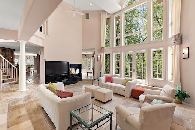 621 Chatfield Rd, New Lenox, IL 60451 - living area featuring decorative columns, a high ceiling, ceiling fan, stone tile flooring, and baseboards