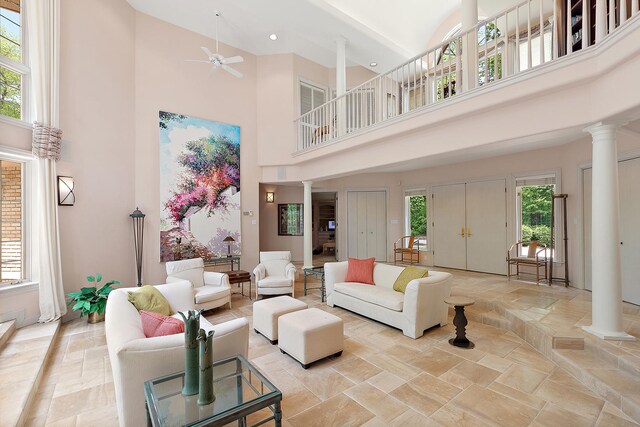 621 Chatfield Rd, New Lenox, IL 60451 - living room featuring decorative columns, a high ceiling, ceiling fan, and light stone finish flooring