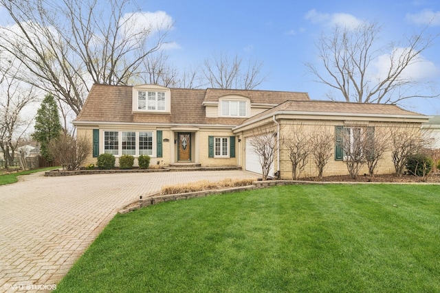 view of front of house with a garage, brick siding, driveway, and a front lawn