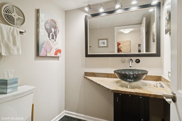 bathroom featuring vanity, baseboards, and toilet