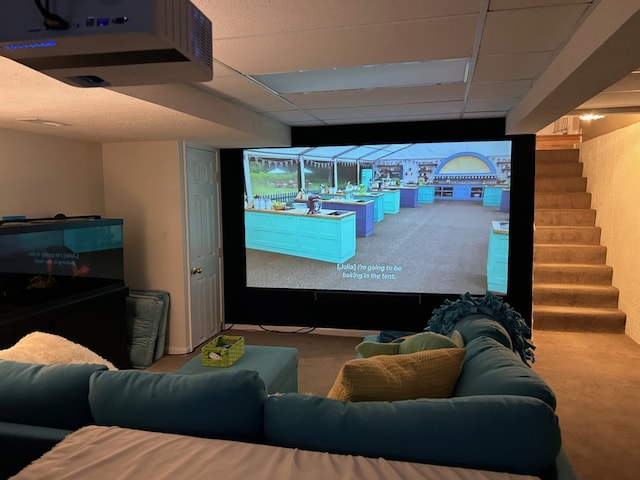 carpeted home theater room with a paneled ceiling