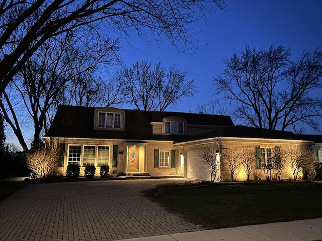 view of front of property featuring an attached garage and decorative driveway
