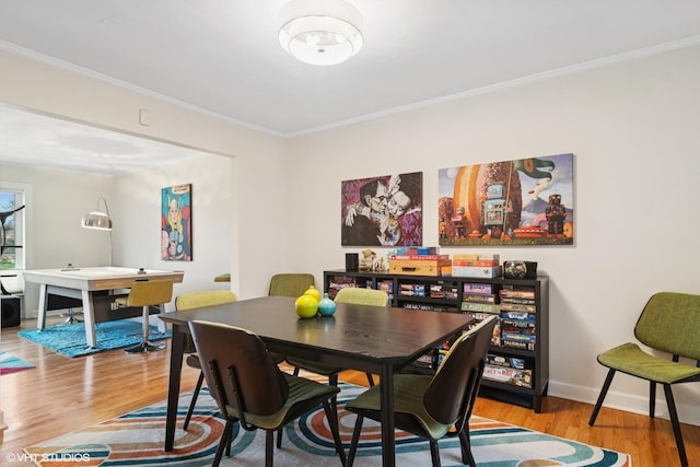 dining area with crown molding, baseboards, and wood finished floors