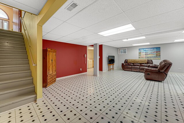 living room featuring baseboards and a paneled ceiling