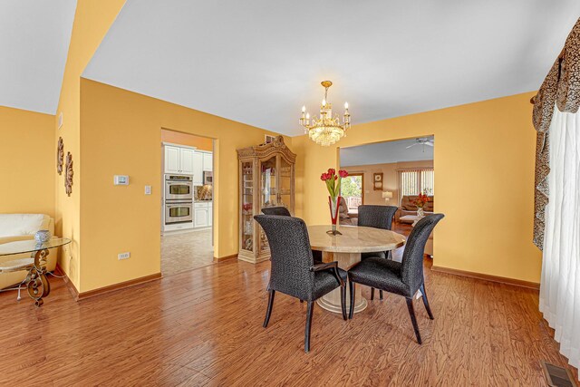 living room featuring high vaulted ceiling, a tiled fireplace, a wealth of natural light, and wood finished floors