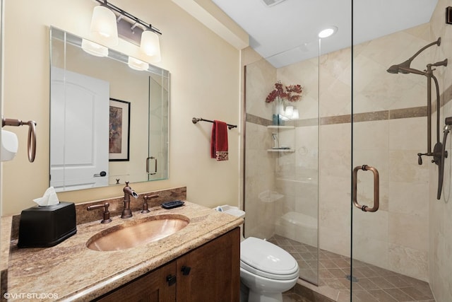 bathroom with toilet, vanity, and a shower stall