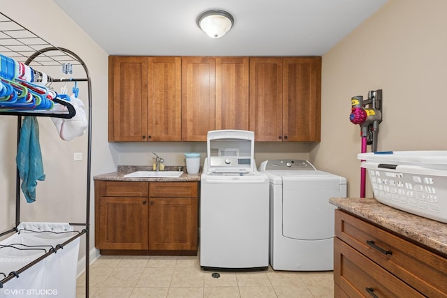 laundry room with a sink, light tile patterned floors, independent washer and dryer, and cabinet space