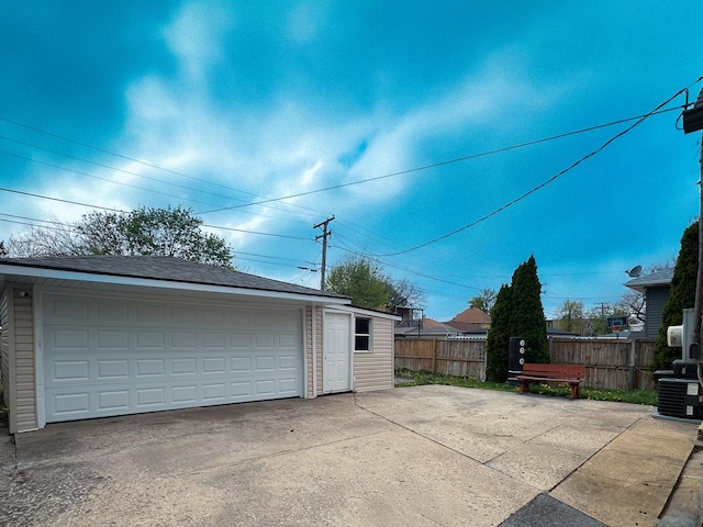 detached garage featuring central AC and fence