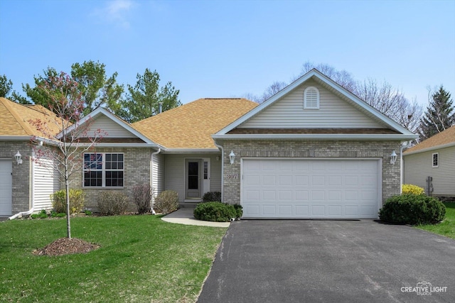 single story home with a front yard, an attached garage, brick siding, driveway, and roof with shingles