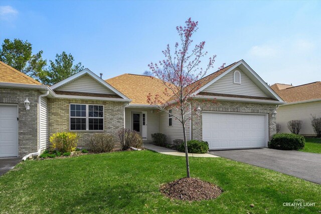 ranch-style home featuring aphalt driveway, brick siding, an attached garage, and a front yard