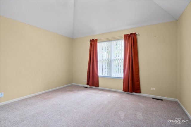 unfurnished room featuring visible vents, carpet flooring, and vaulted ceiling
