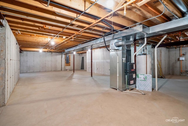 unfinished below grade area featuring electric panel and heating unit