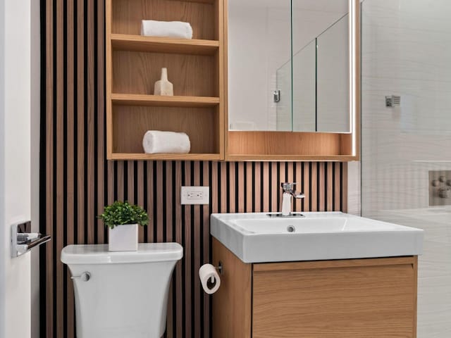 1355 N Sandburg Ter Unit 906D, Chicago, IL 60610 - bathroom with wallpapered walls, toilet, and vanity