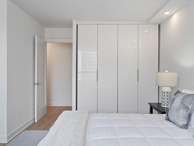 1355 N Sandburg Ter Unit 906D, Chicago, IL 60610 - bedroom with a closet, baseboards, wood finished floors, and recessed lighting