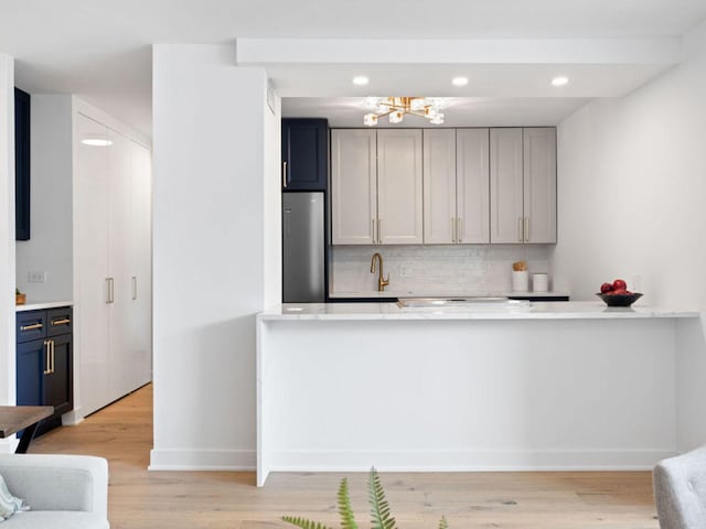1355 N Sandburg Ter Unit 906D, Chicago, IL 60610 - kitchen featuring freestanding refrigerator, light countertops, backsplash, and light wood finished floors