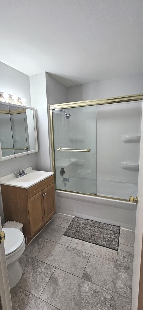 2508 Algonquin Rd Unit 5, Rolling Meadows, IL 60008 - bathroom with toilet, vanity, and shower / bath combination with glass door