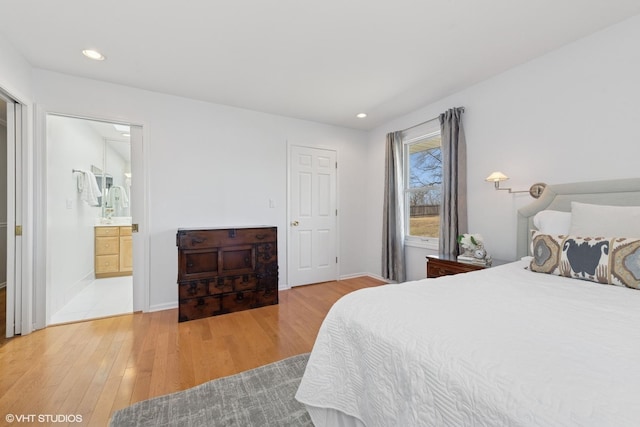 bedroom with baseboards, ensuite bath, recessed lighting, and light wood finished floors