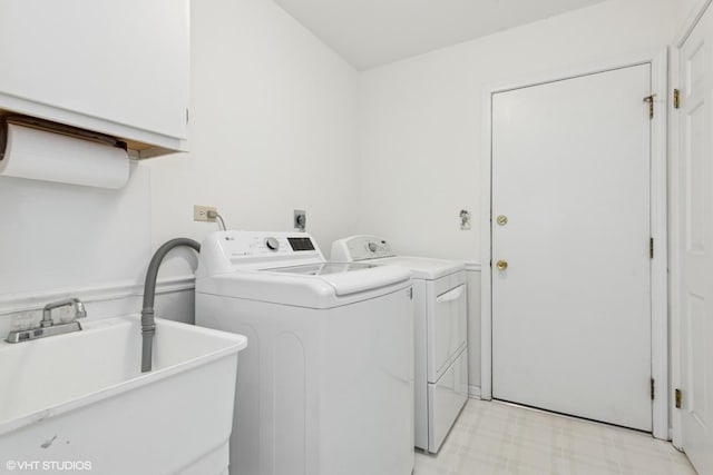 clothes washing area with a sink, separate washer and dryer, and light floors