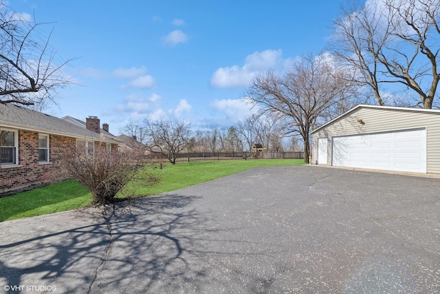 exterior space featuring an outbuilding, fence, and a detached garage